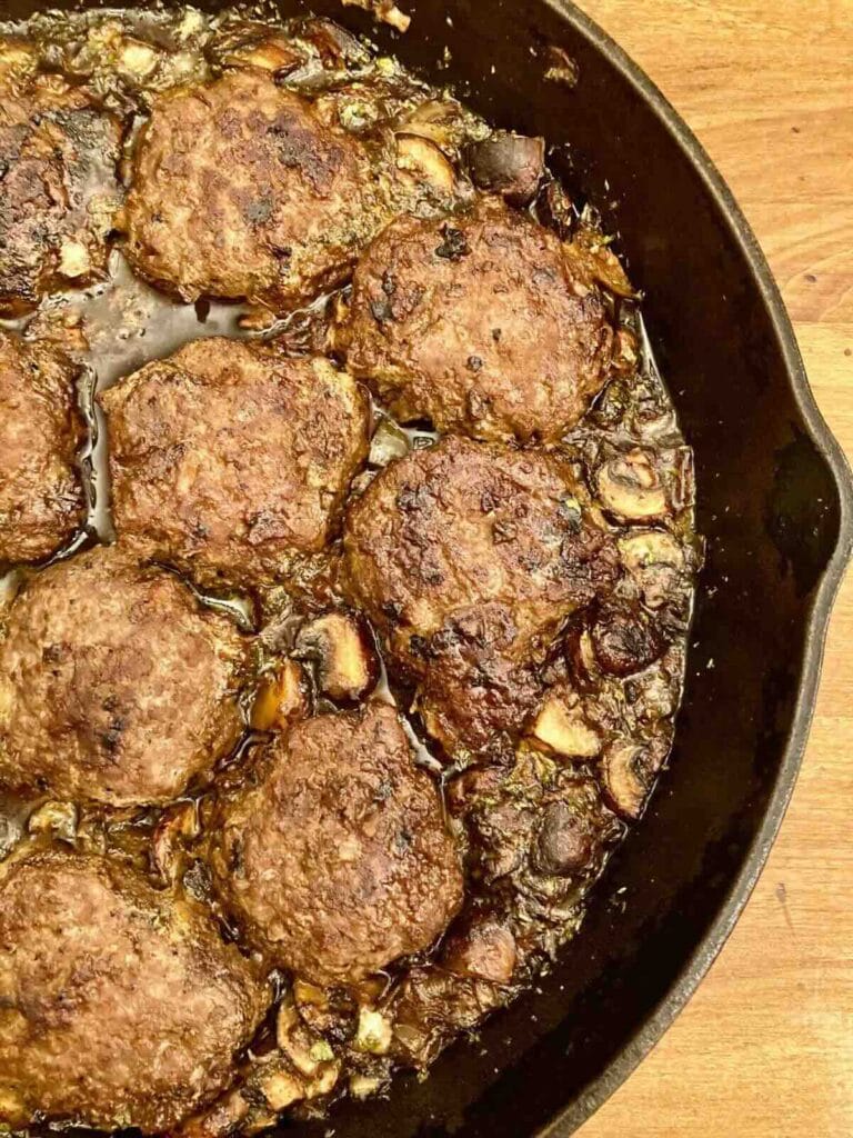 Half a cast iron skillet with gluten-free Salisbury Steak