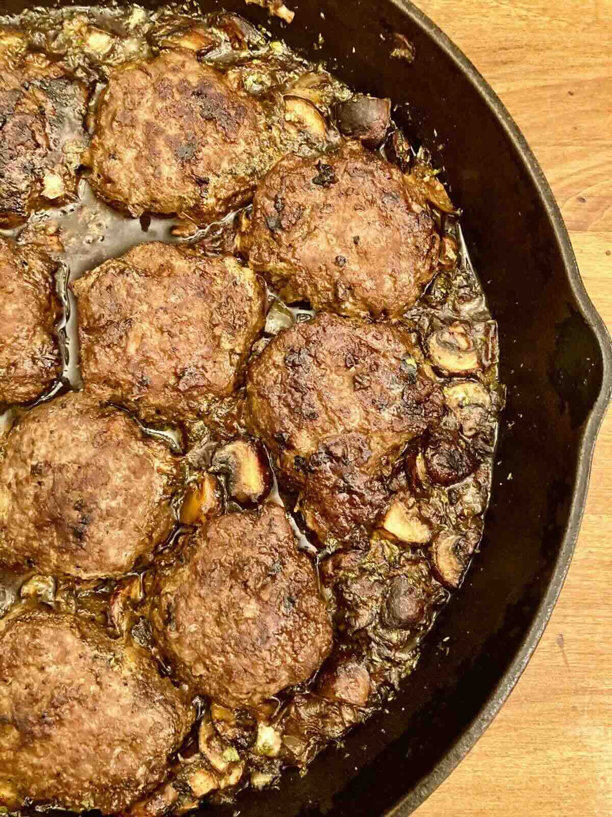 Half a cast iron skillet with gluten-free Salisbury Steak