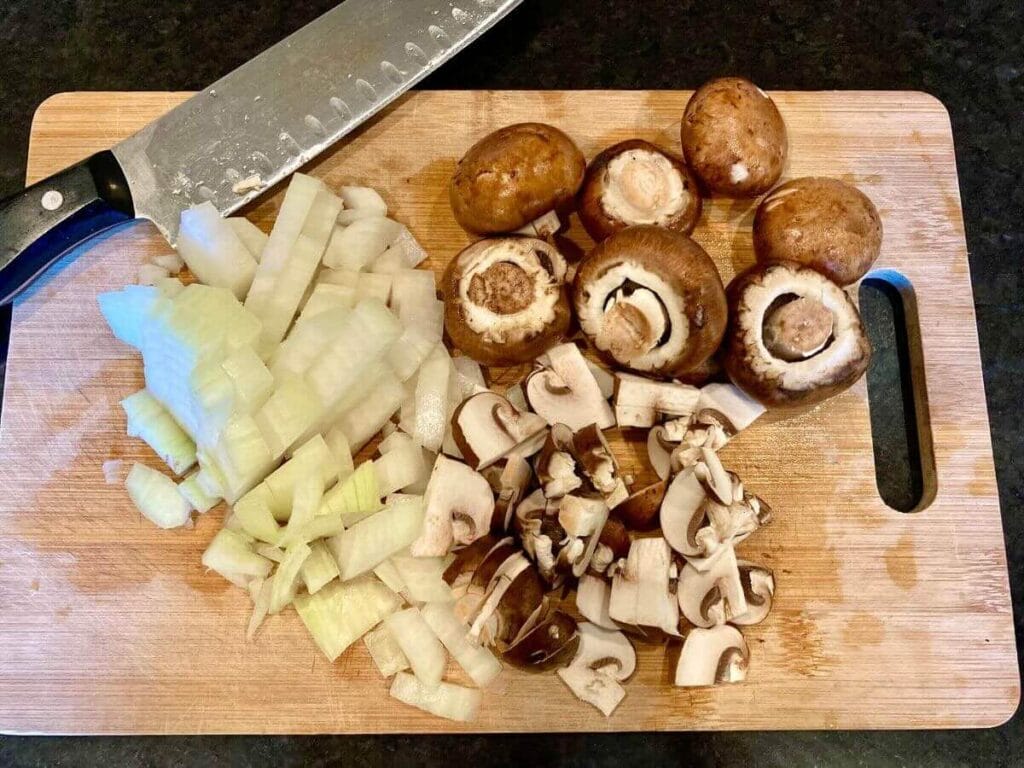 Chopped onions and mushrooms on cutting board