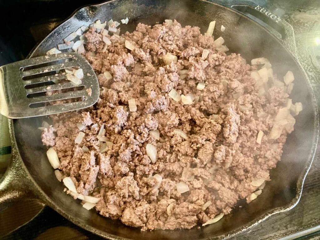 Browning ground beef and onions in skillet