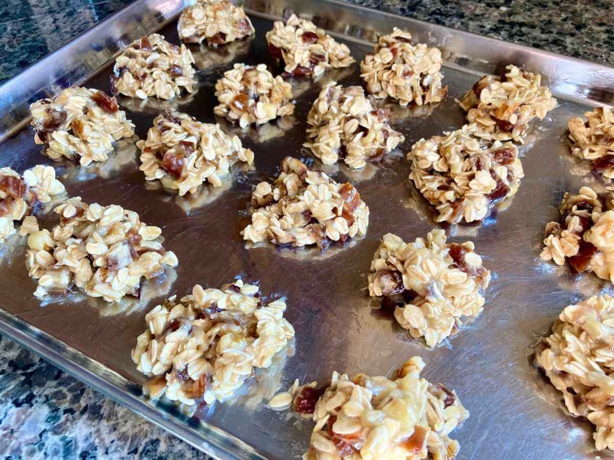 Unbaked banana and date oatmeal cookies on a cookie sheet.