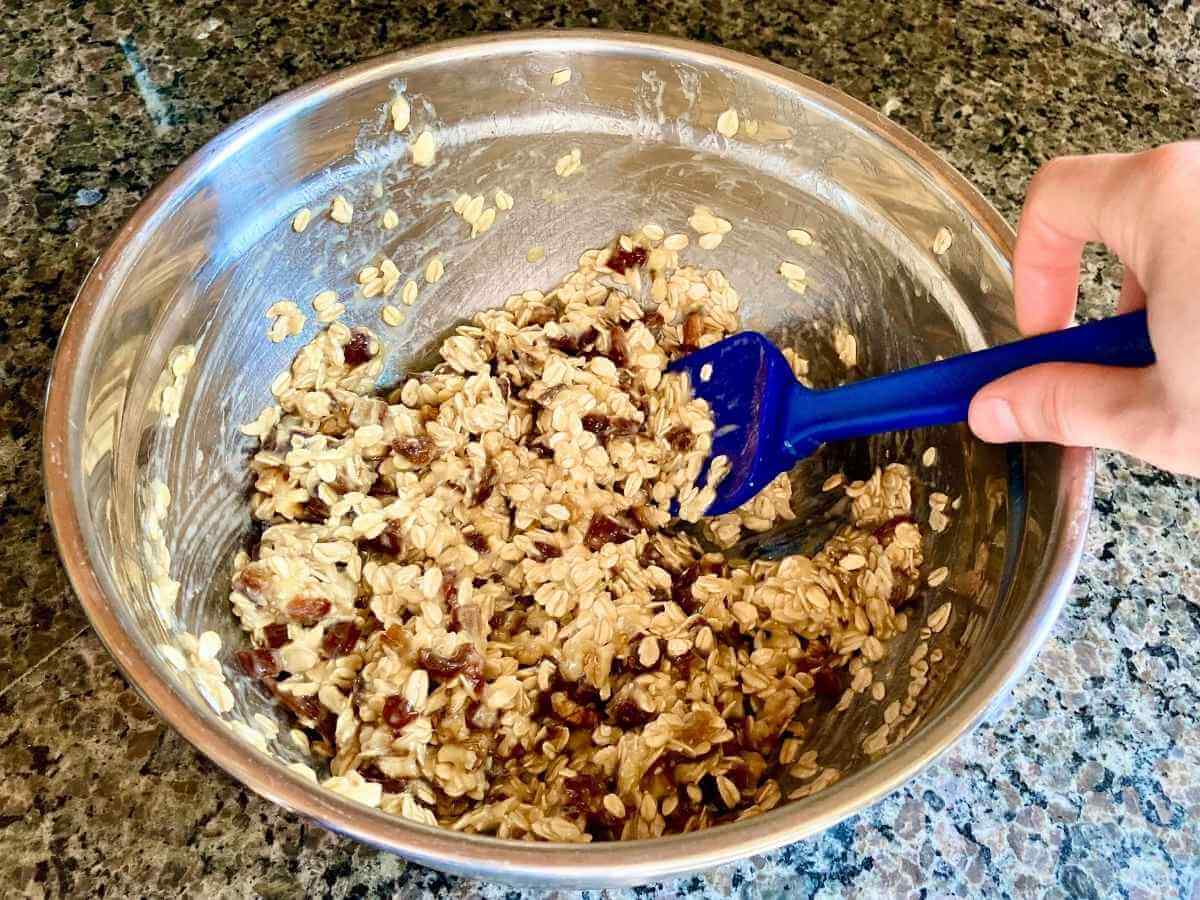 Stirring banana and date oatmeal cookie batter.