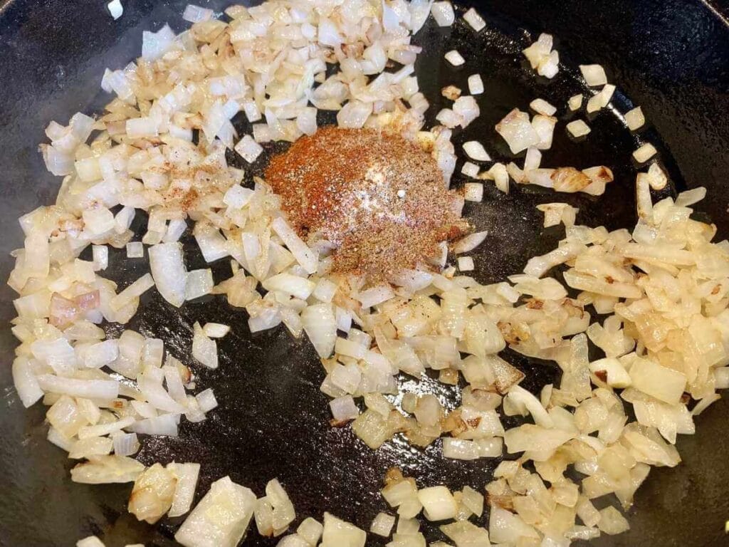 Onion and spices in a skillet.