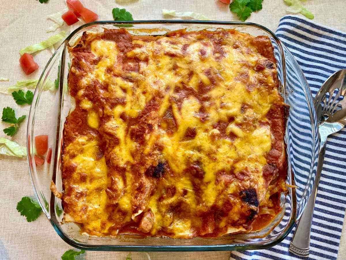 Chicken and cilantro enchiladas in a baking dish.