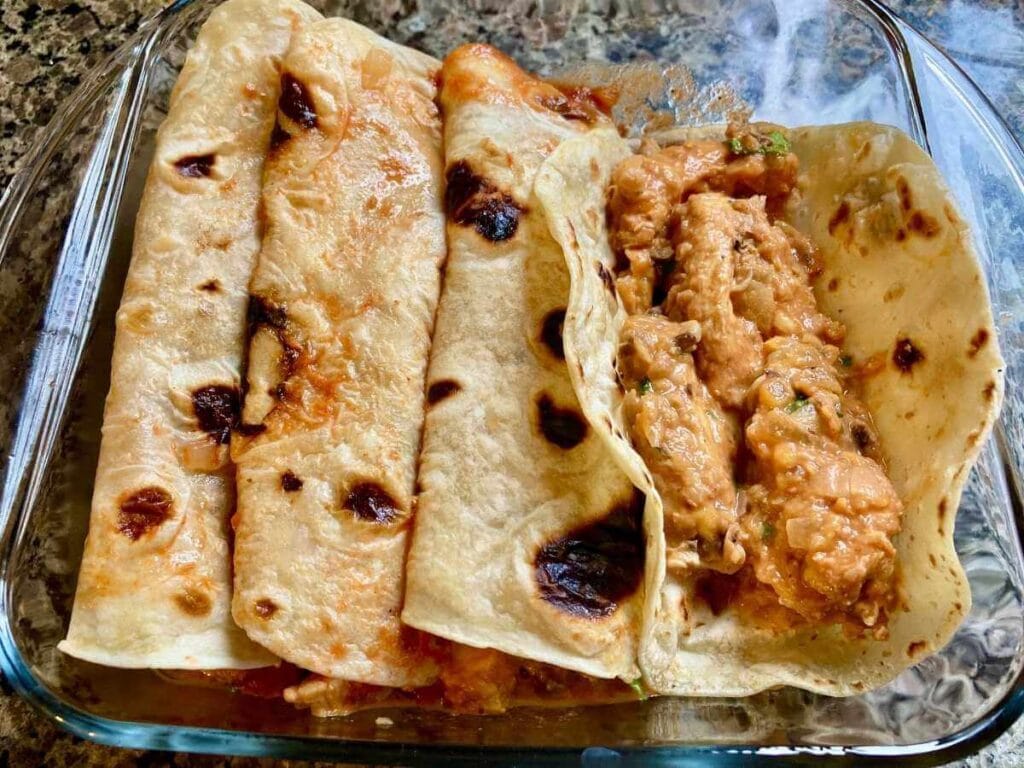 Filling tortillas with enchilada filling.