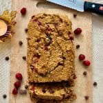 Pumpkin cranberry bread on a cutting board.