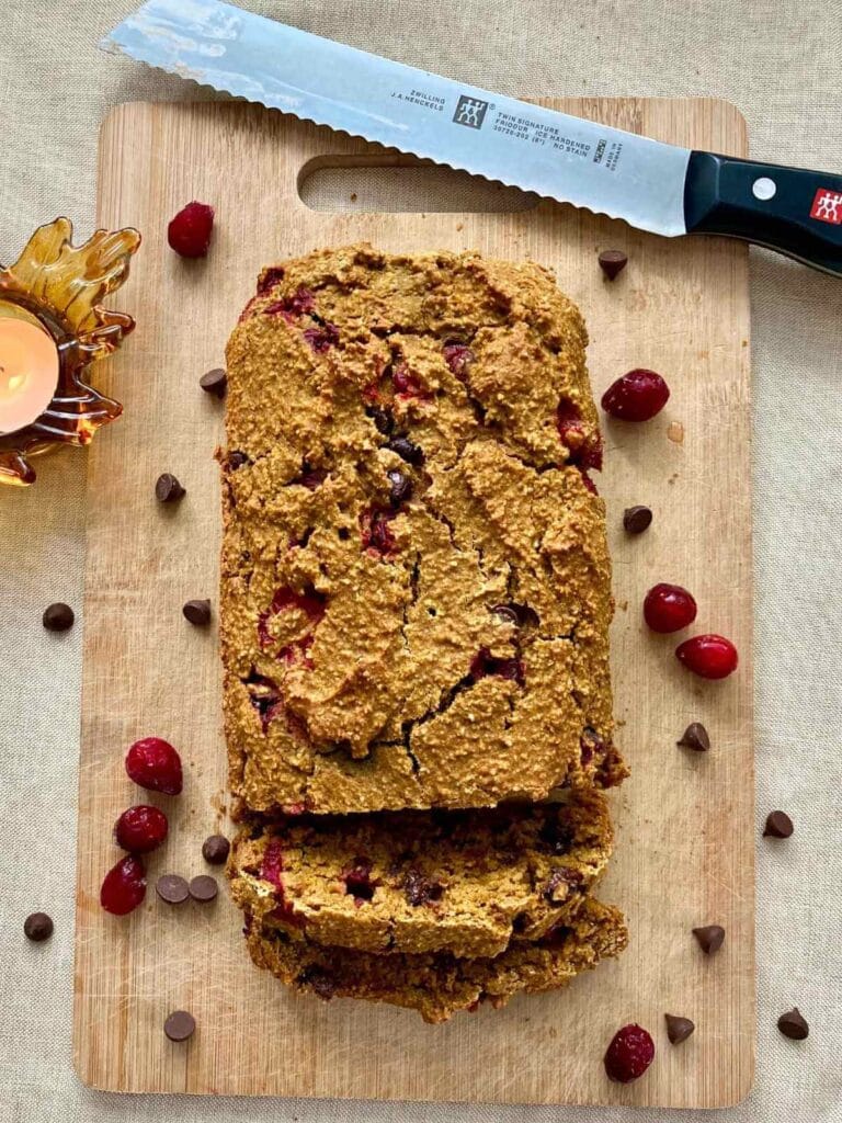 Pumpkin cranberry bread on a cutting board.