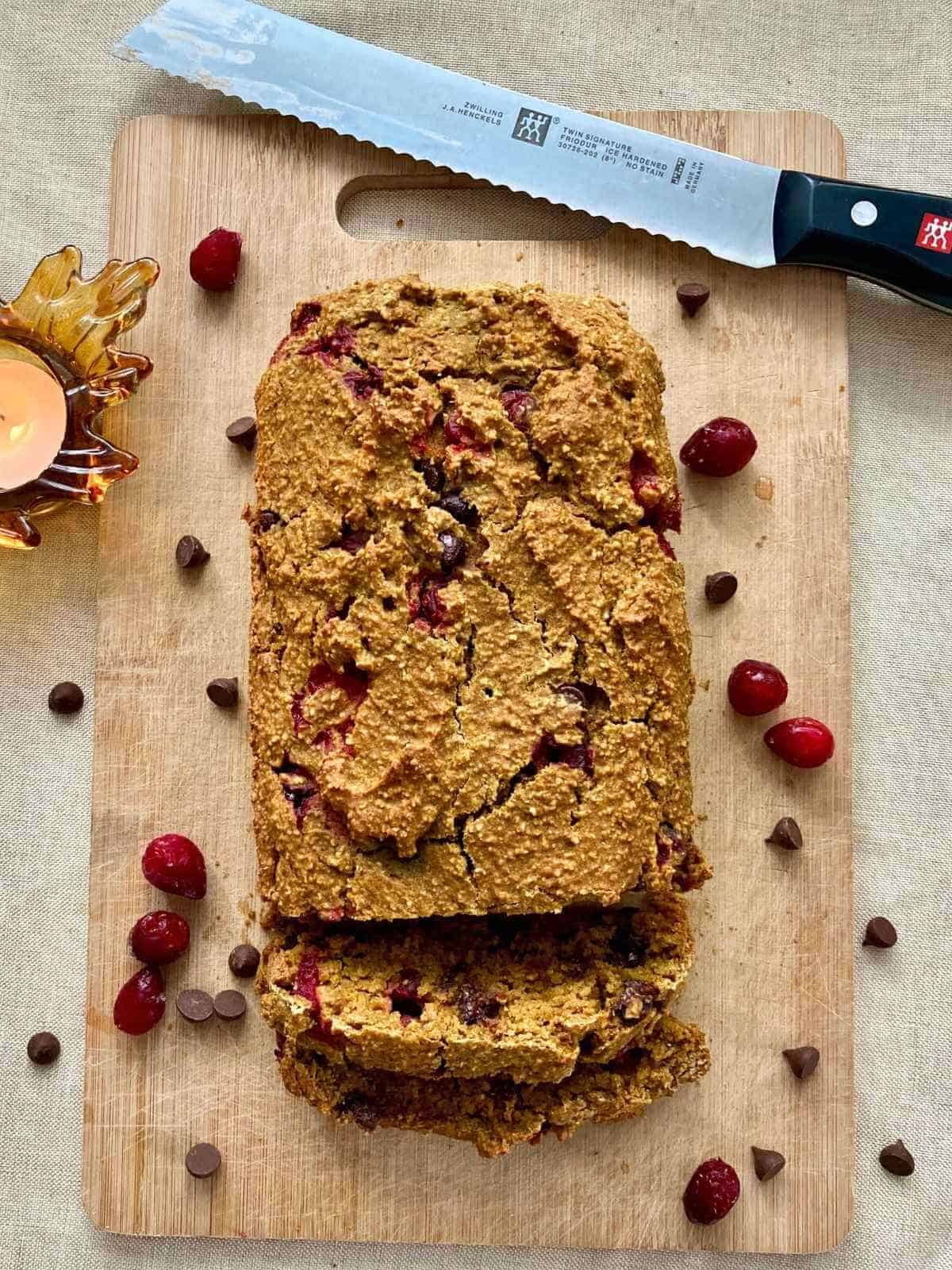 Pumpkin cranberry bread on a cutting board.