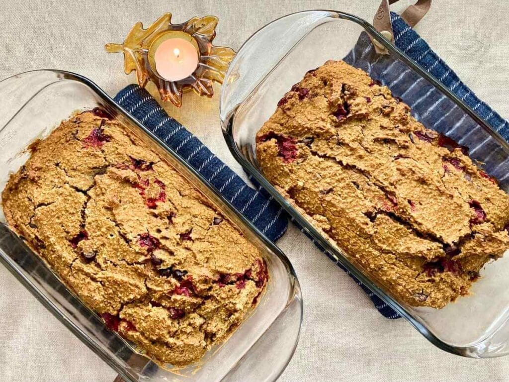 2 loaves of pumpkin cranberry bread in bread pans.