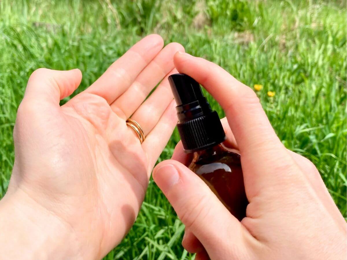 Spraying hand sanitizer onto hands.