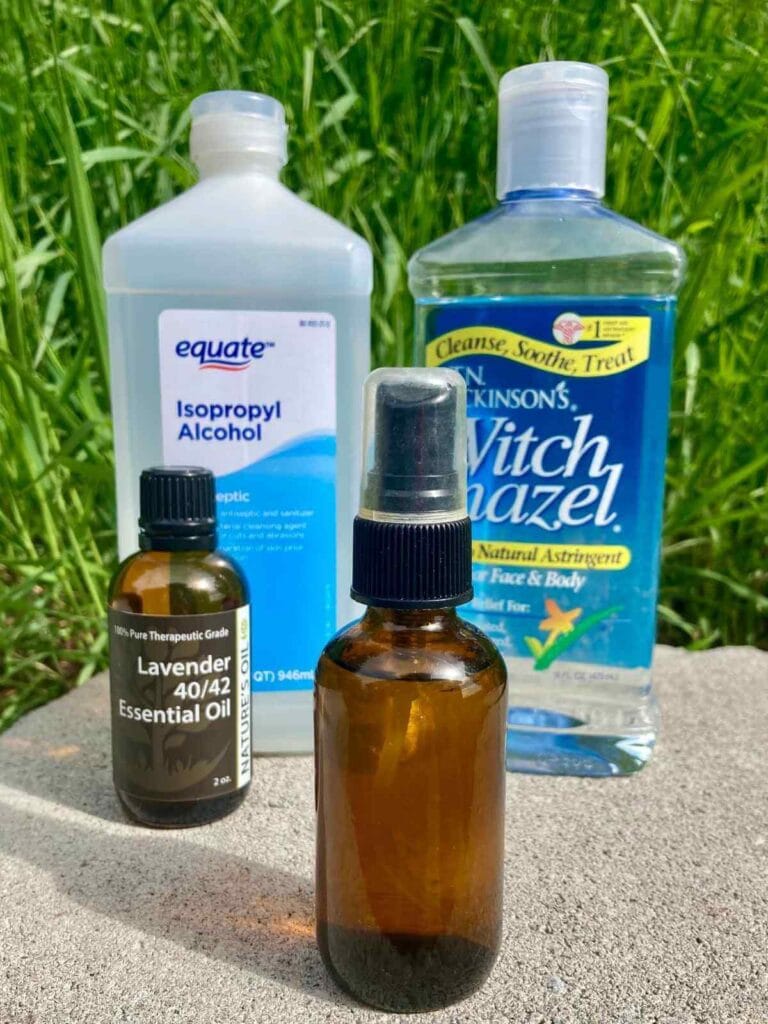 Rubbing alcohol, lavender oil, and witch hazel with a bottle of hand sanitizer spray.