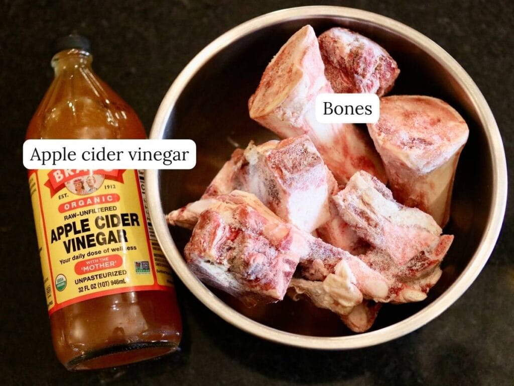Ingredients for bone broth including bones and apple cider vinegar.