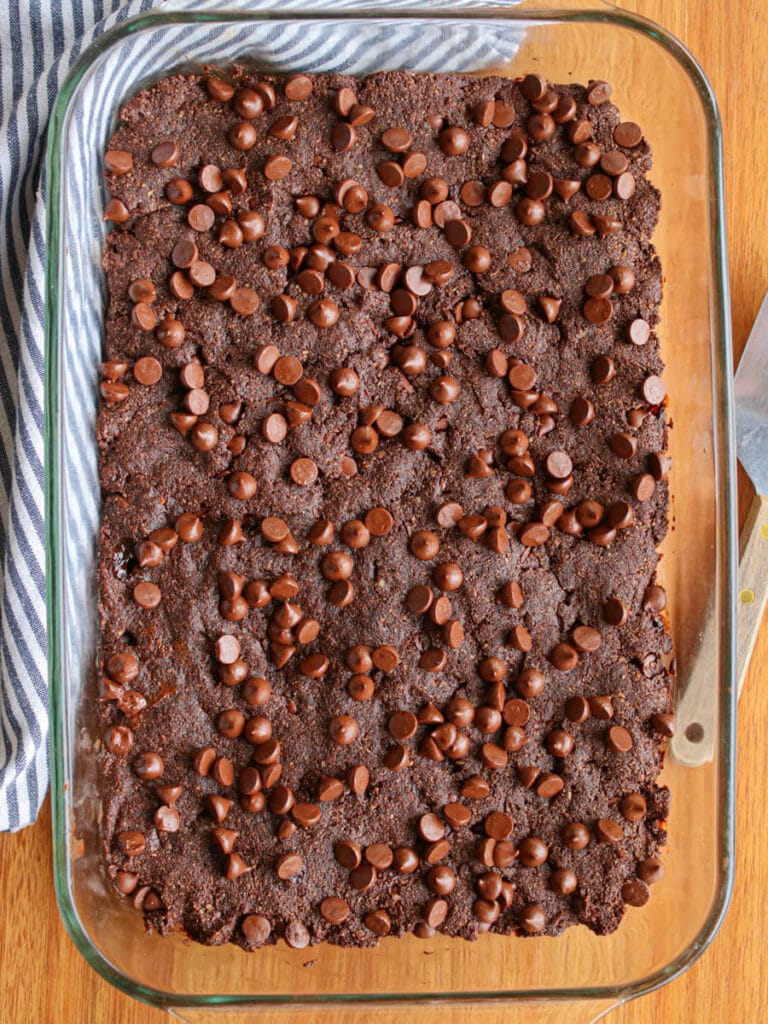 A pan of vegan almond flour brownies warm right out of the oven on a wooden table.