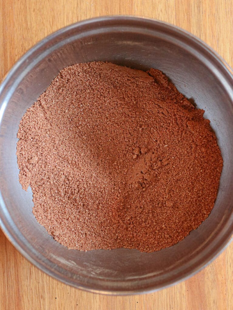 Dry brownie ingredients mixed together in a metal bowl.