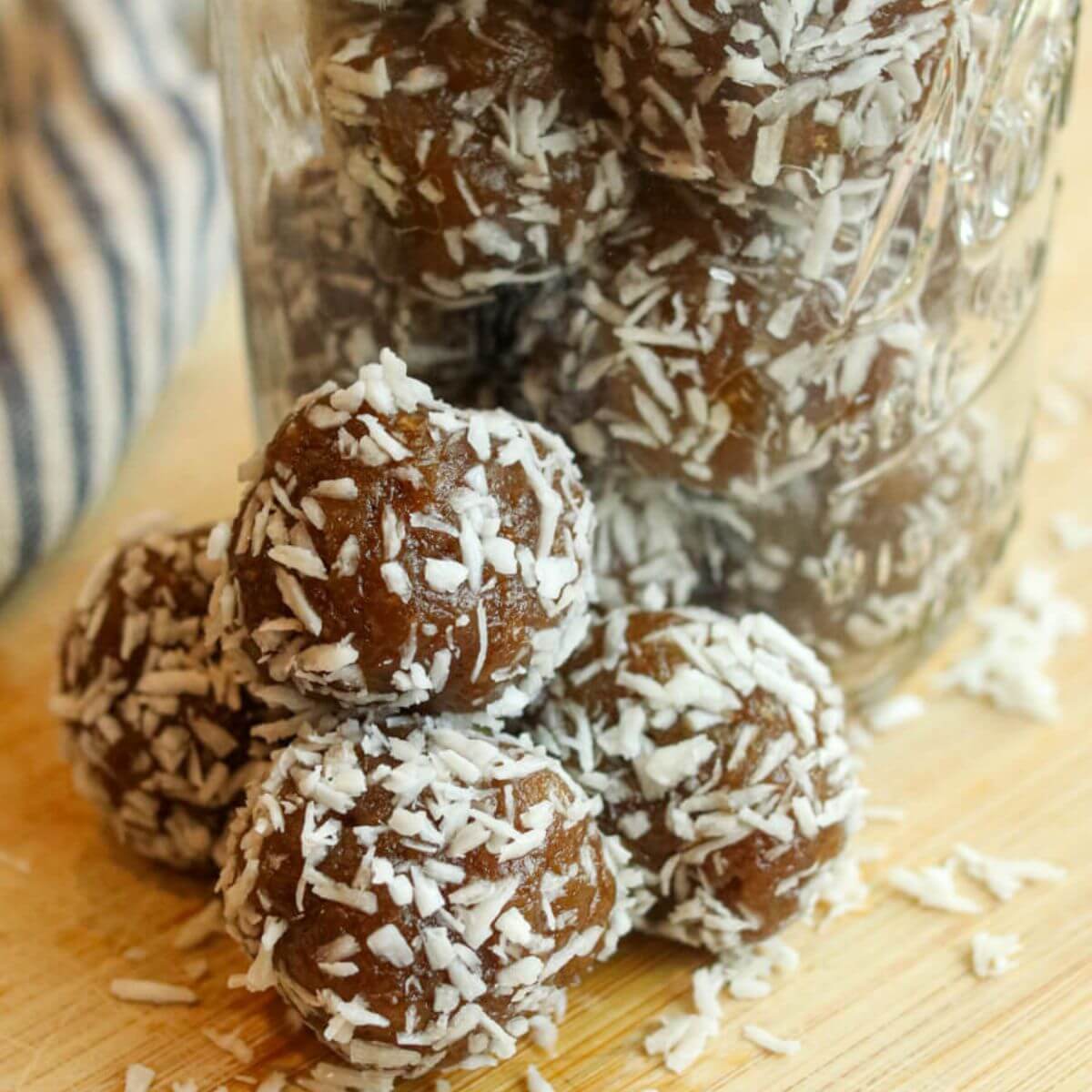 Closeup view of energy balls with dates beside a jar full of them.