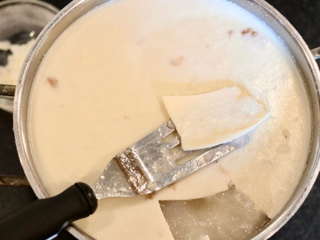 Skimming fat off the top of cold bone broth.