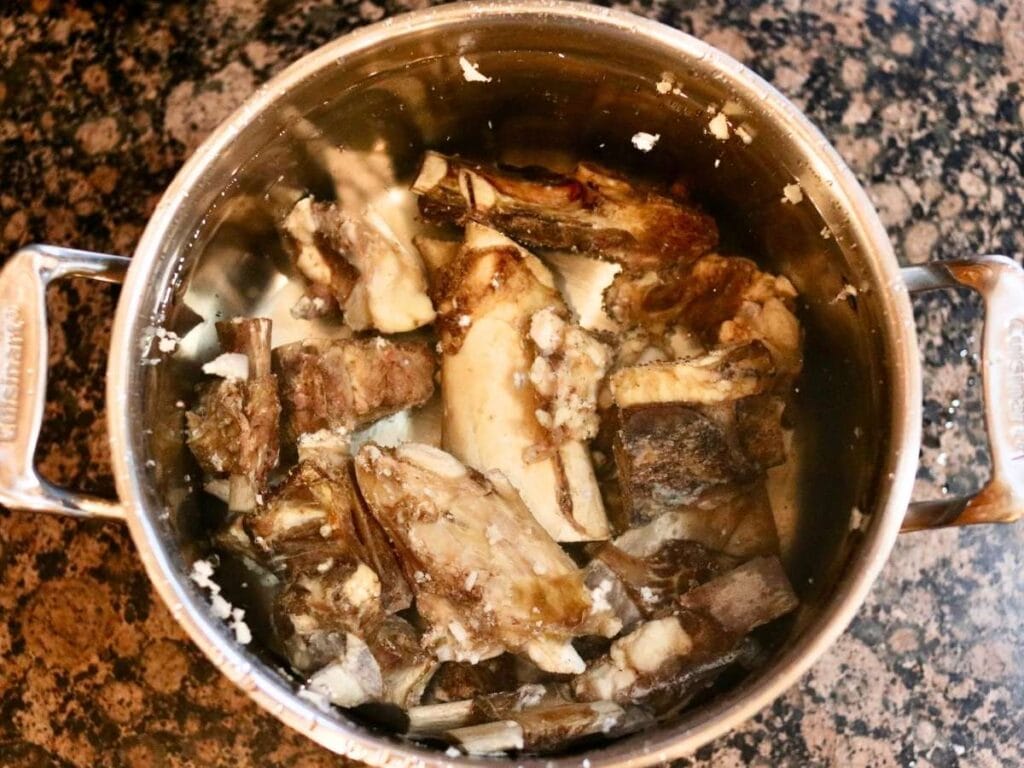 Pot full of roasted beef bones and water.