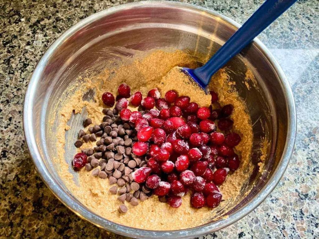 Stirring cranberries and chocolate chips into batter.