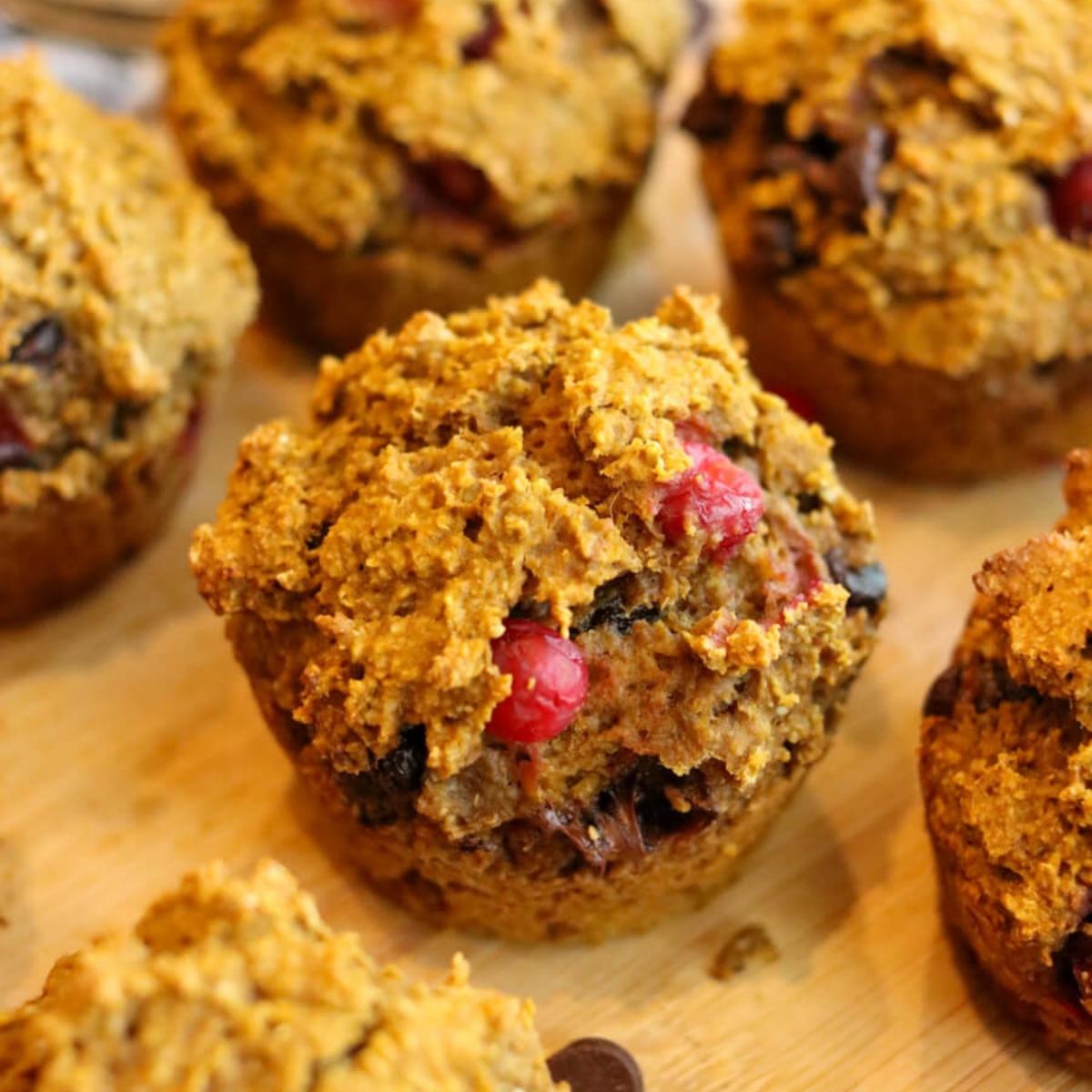 Close-up view of a gluten-free pumpkin muffin on a wooden surface.