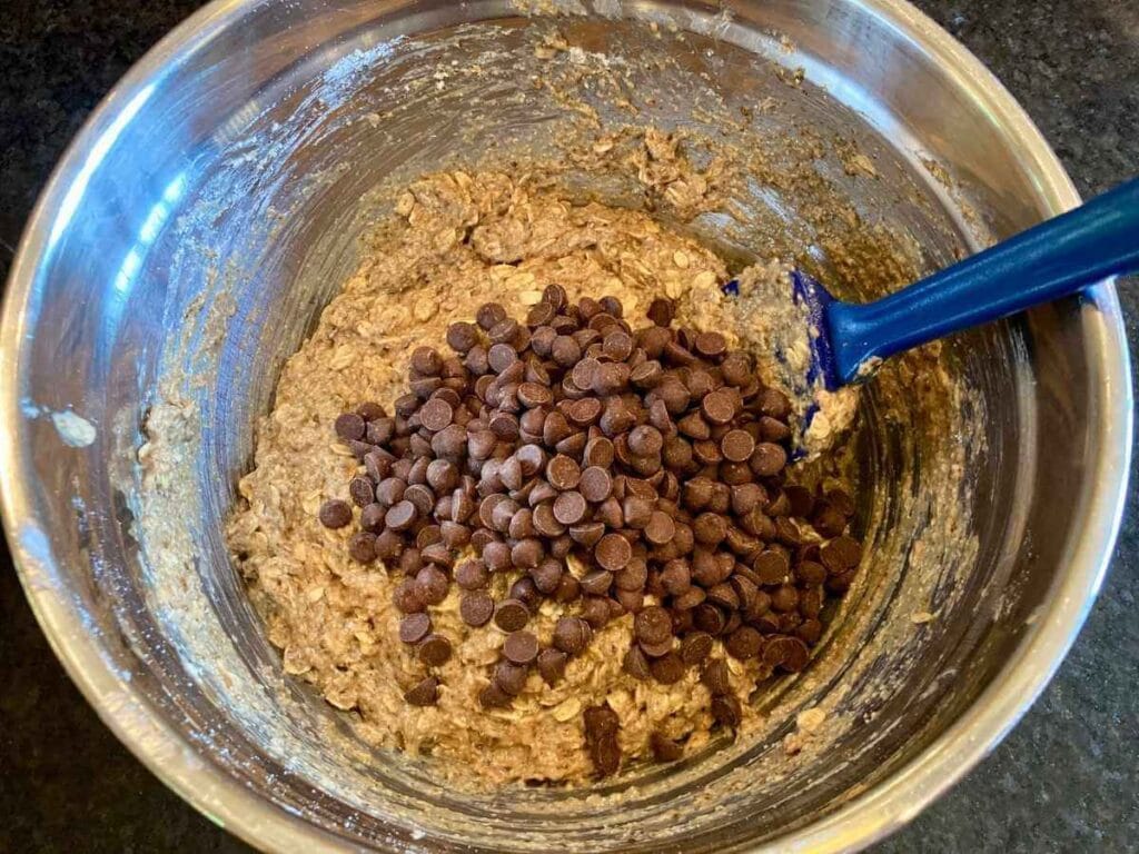 Adding chocolate chips to cookie dough.