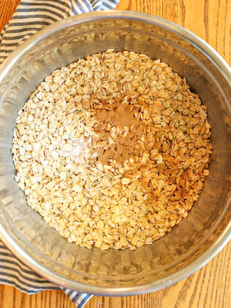 Oats, oat flour, and other dry ingredients in a mixing bowl on a table.