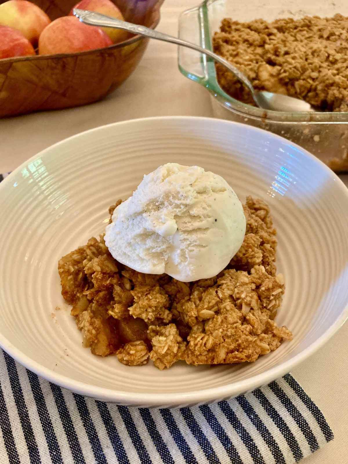 Closeup of apple crisp with ice cream in a bowl.