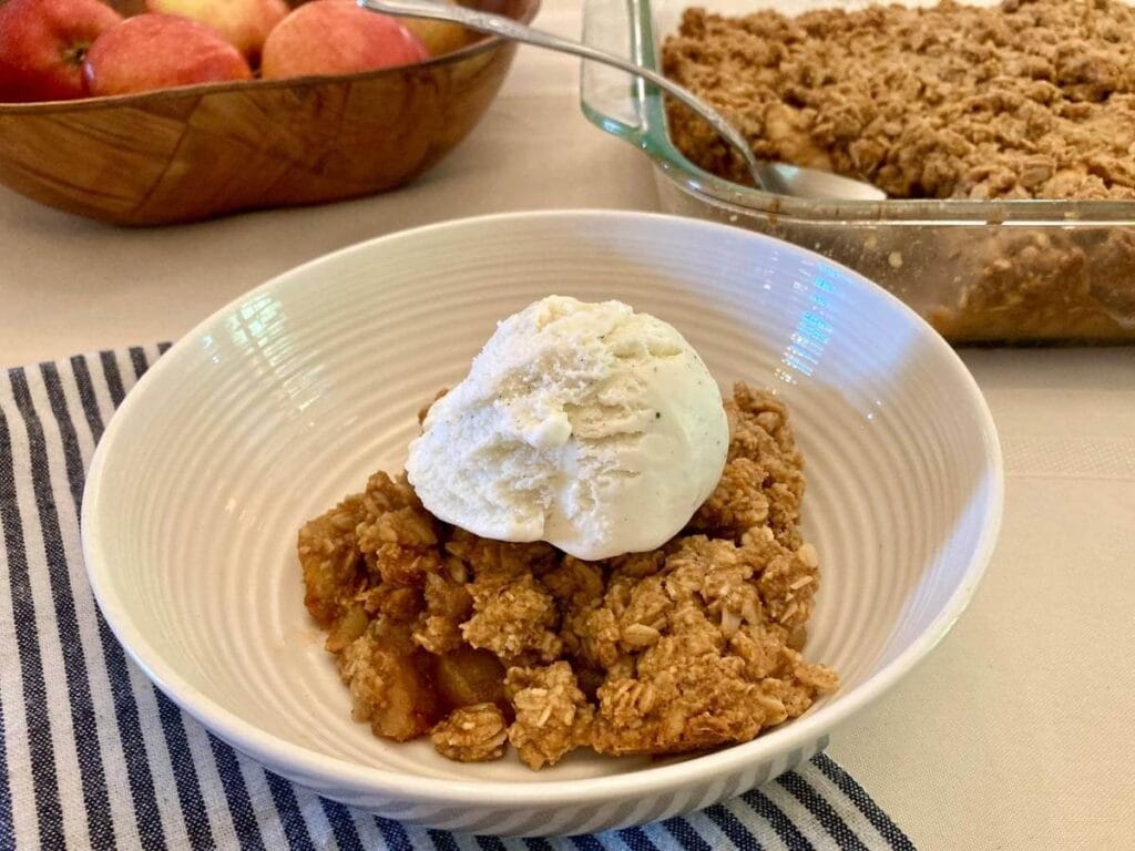 Apple crisp with ice cream in a bowl.