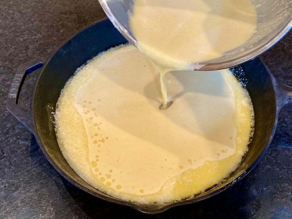 Pouring batter into a skillet.