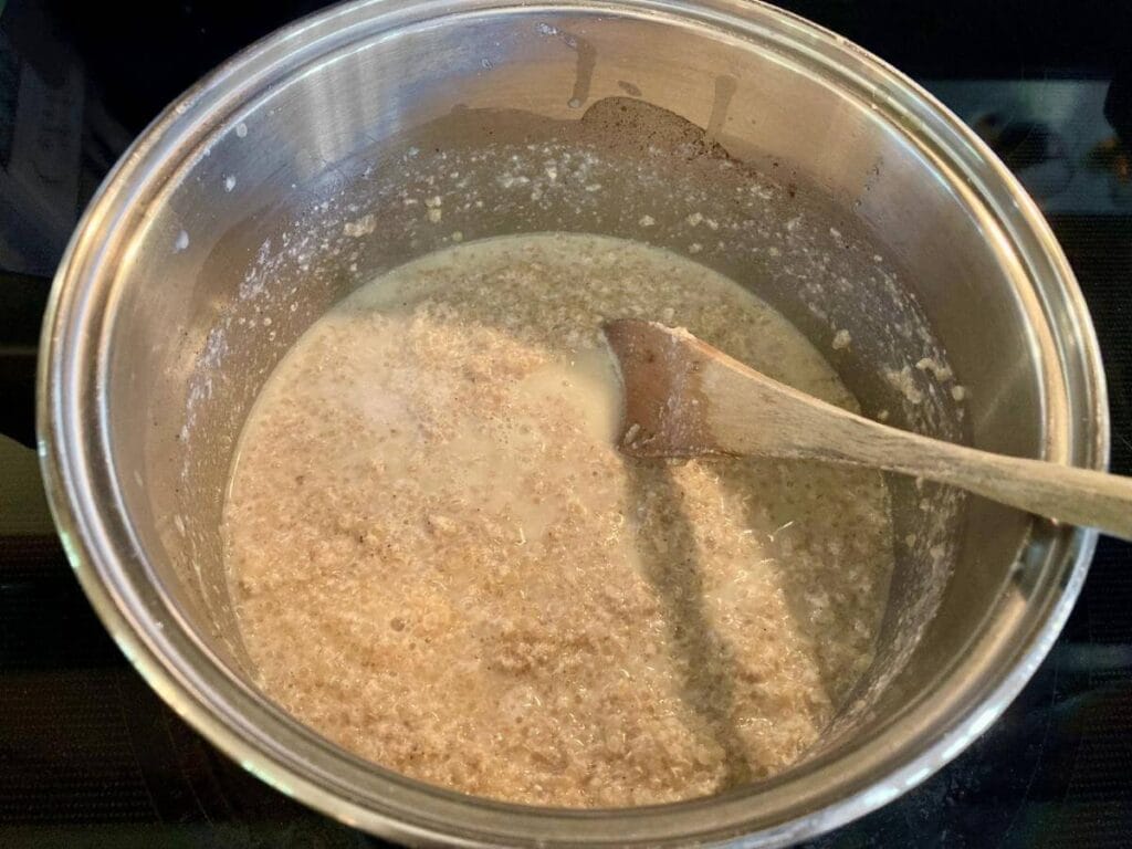 Stirring quinoa pudding in a saucepan.