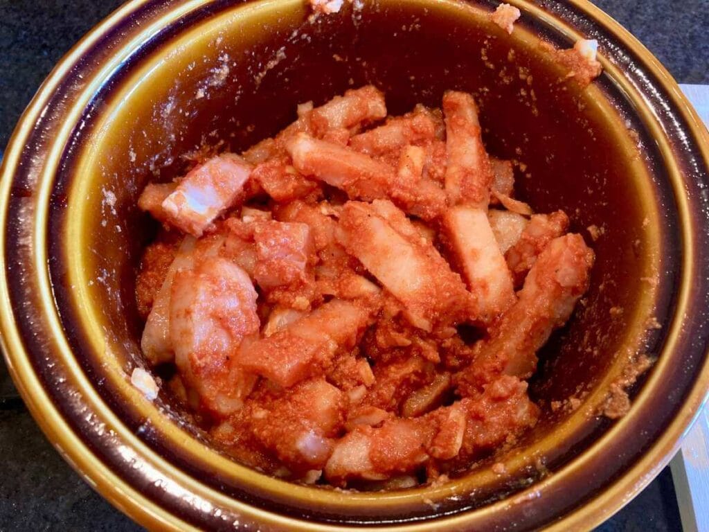 Chicken and tomato sauce mixture in a slow cooker.