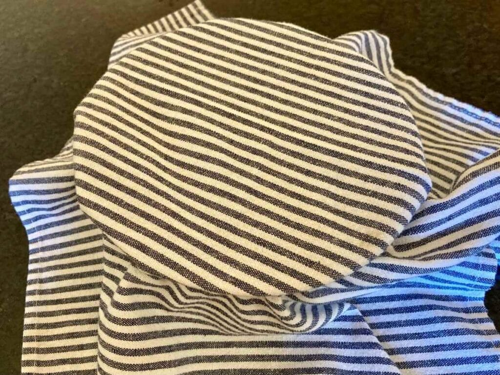 A cloth napkin over a bowl of soaking quinoa.