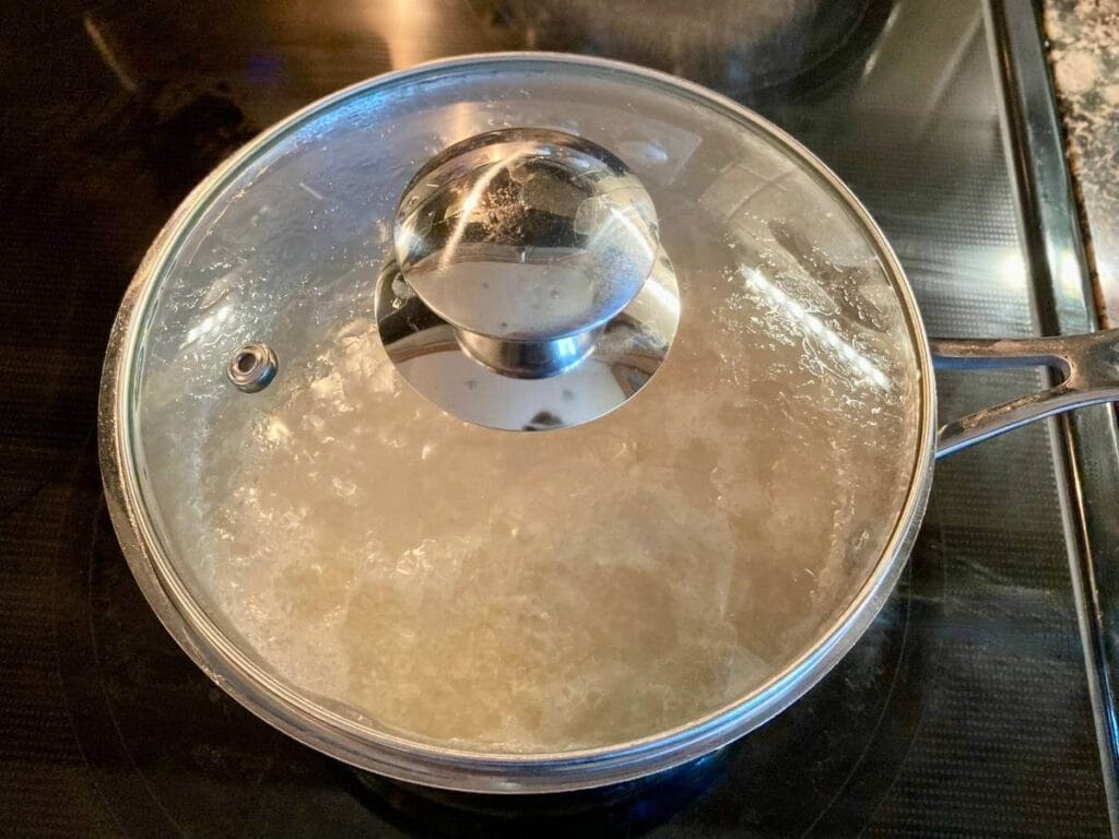 Lid on a pot of cooking quinoa.