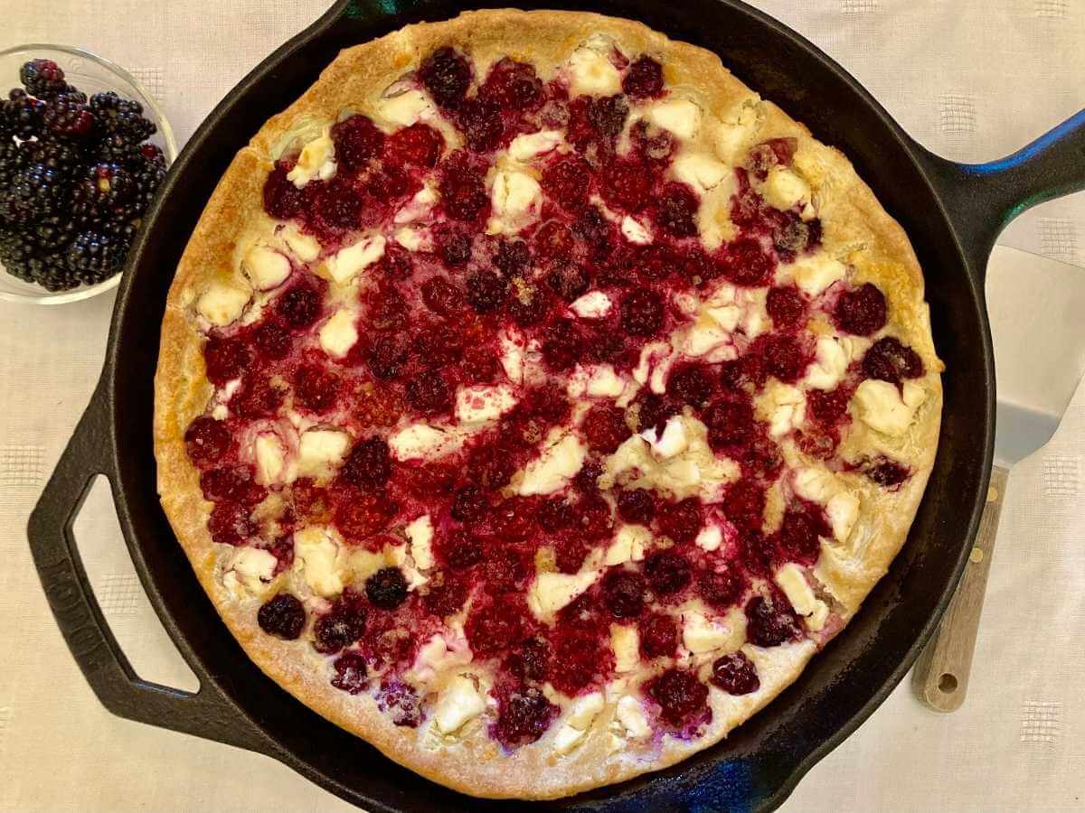 Blackberry cheesecake German pancakes in a skillet fresh out of the oven.