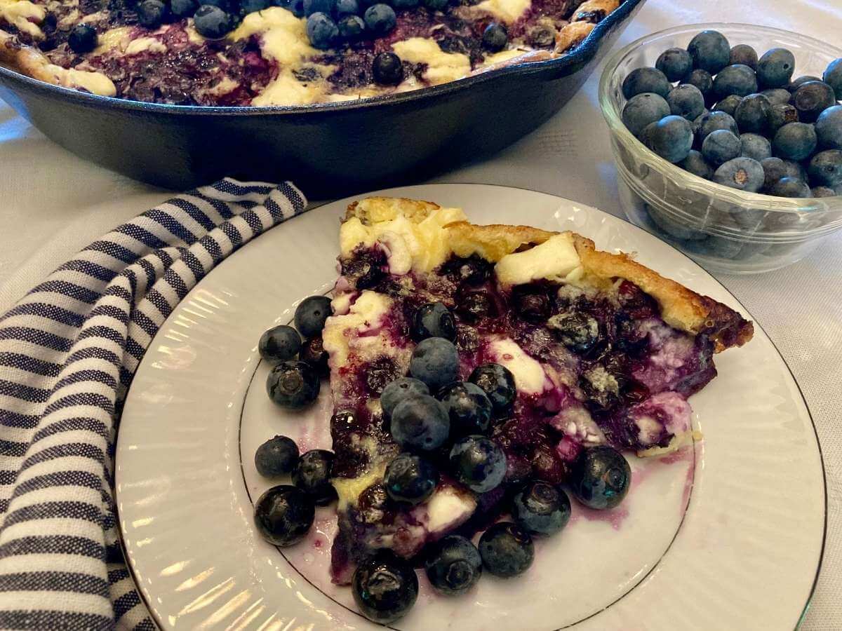 Slice of blueberry cheesecake German pancake on a plate.