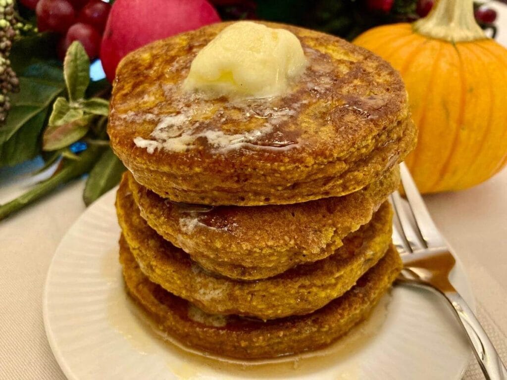 Stack of gluten-free pumpkin pancakes on a plate.
