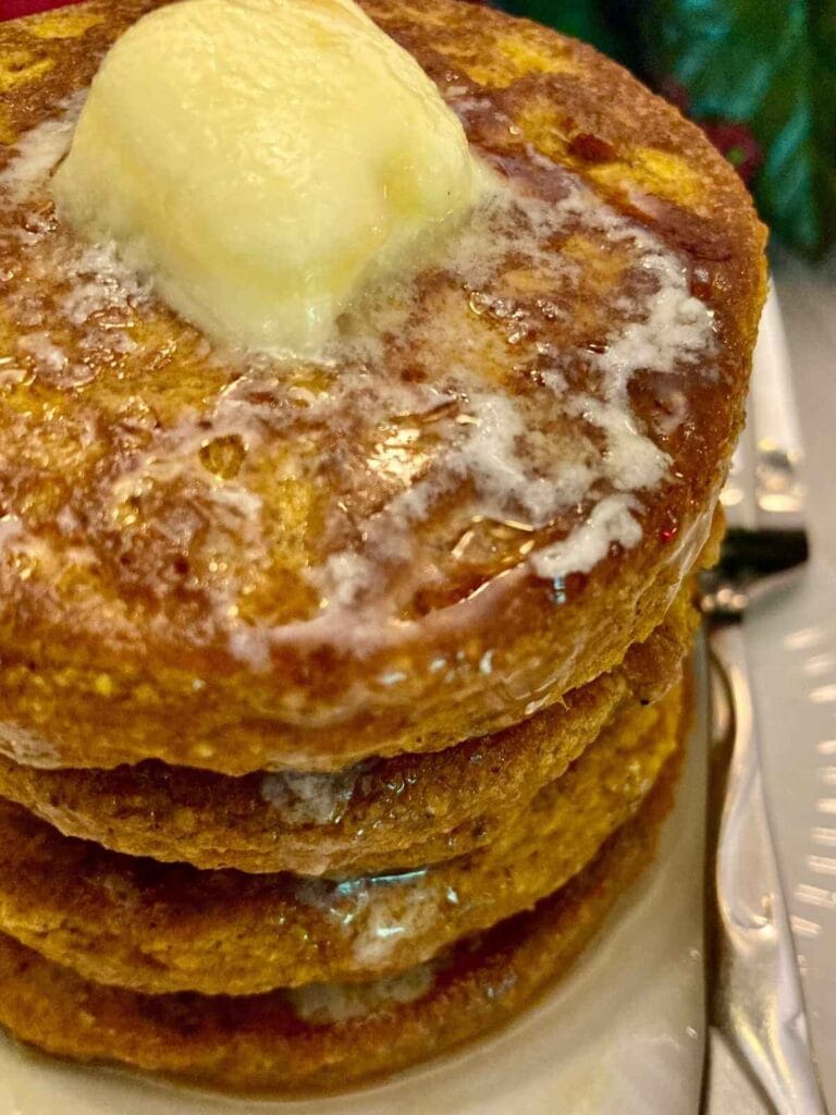 Closeup of a stack of gluten-free pumpkin pancakes on a plate.