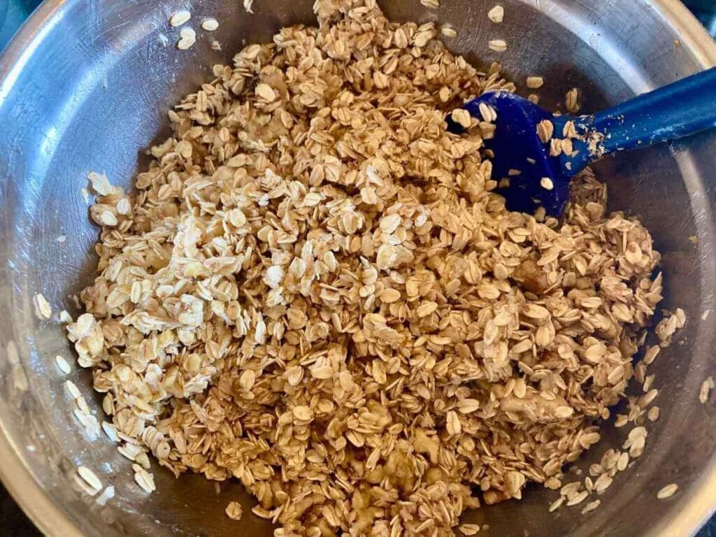 Stirring oat mixture in a mixing bowl.