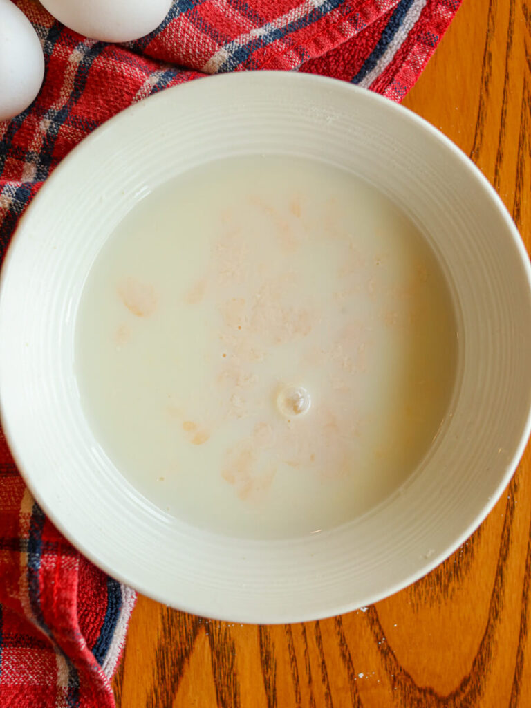 Milk and apple cider vinegar mixed in a bowl on a table.