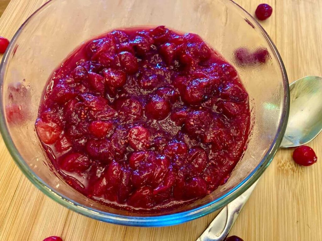 Refined sugar-free cranberry sauce in a glass bowl with a spoon.