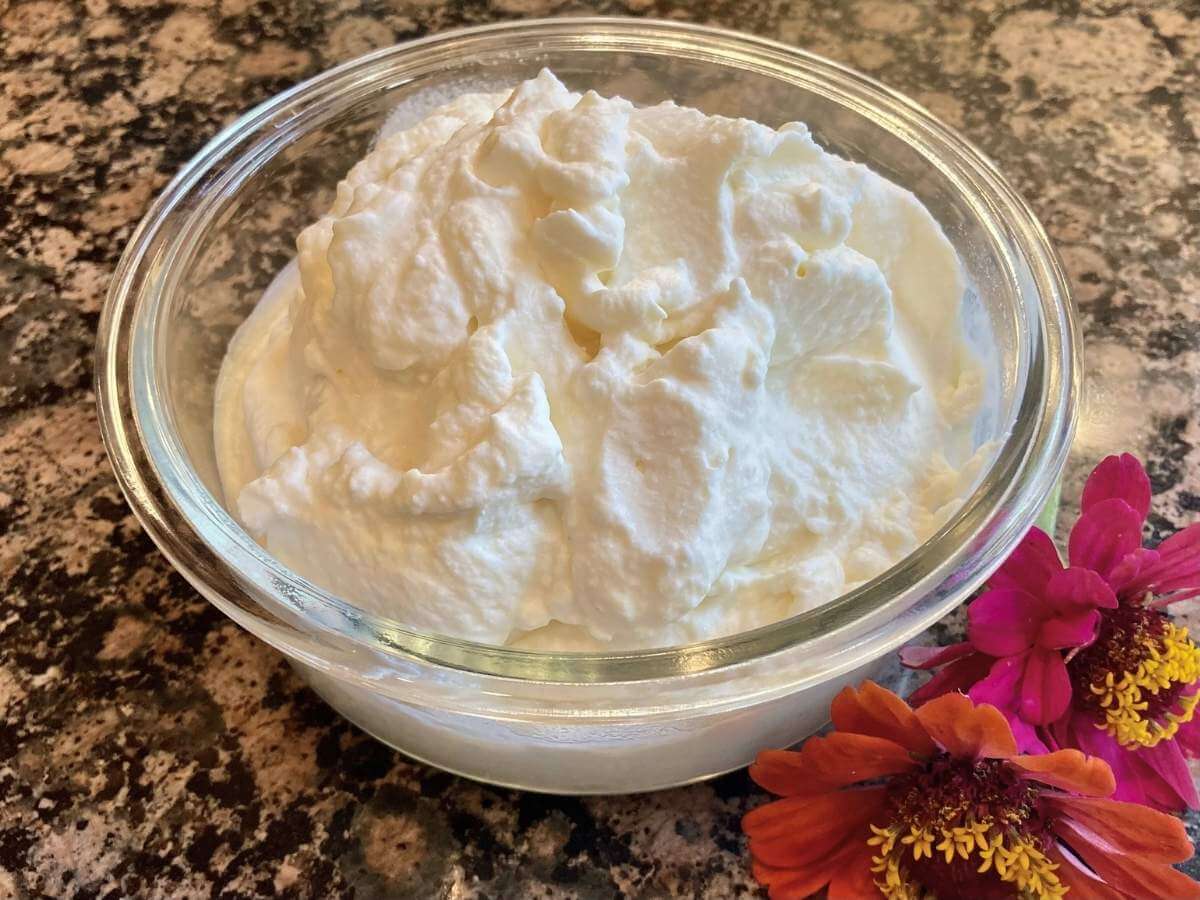 Whipped cream in a bowl on a counter.