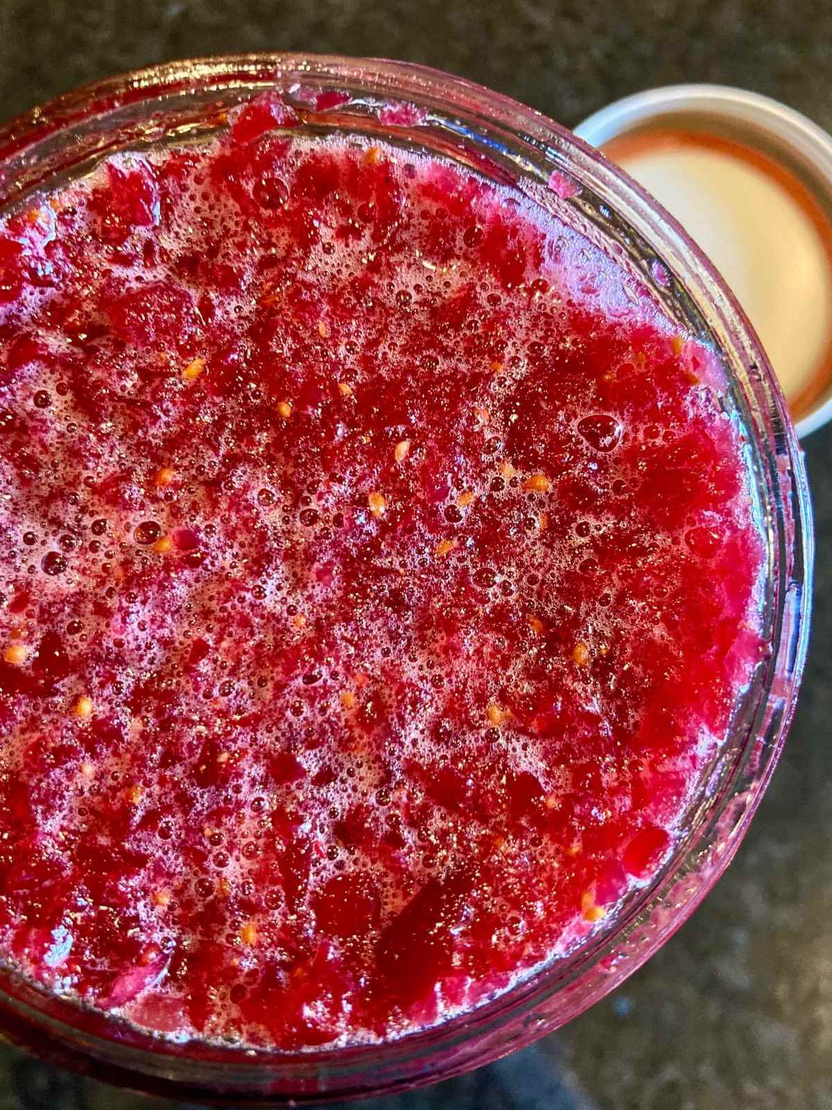 Open jar with fermented cranberries.