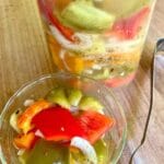 Fermented peppers and onions in a bowl and a jar.
