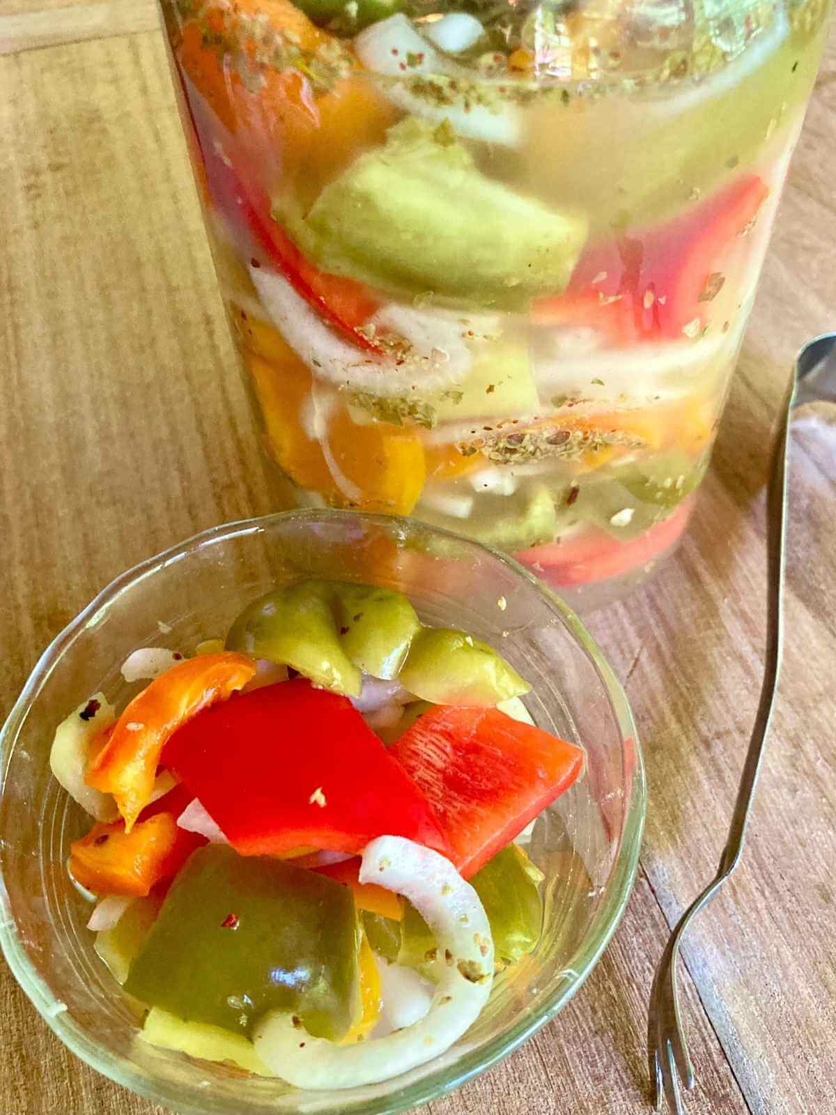 Fermented peppers and onions in a bowl and a jar.