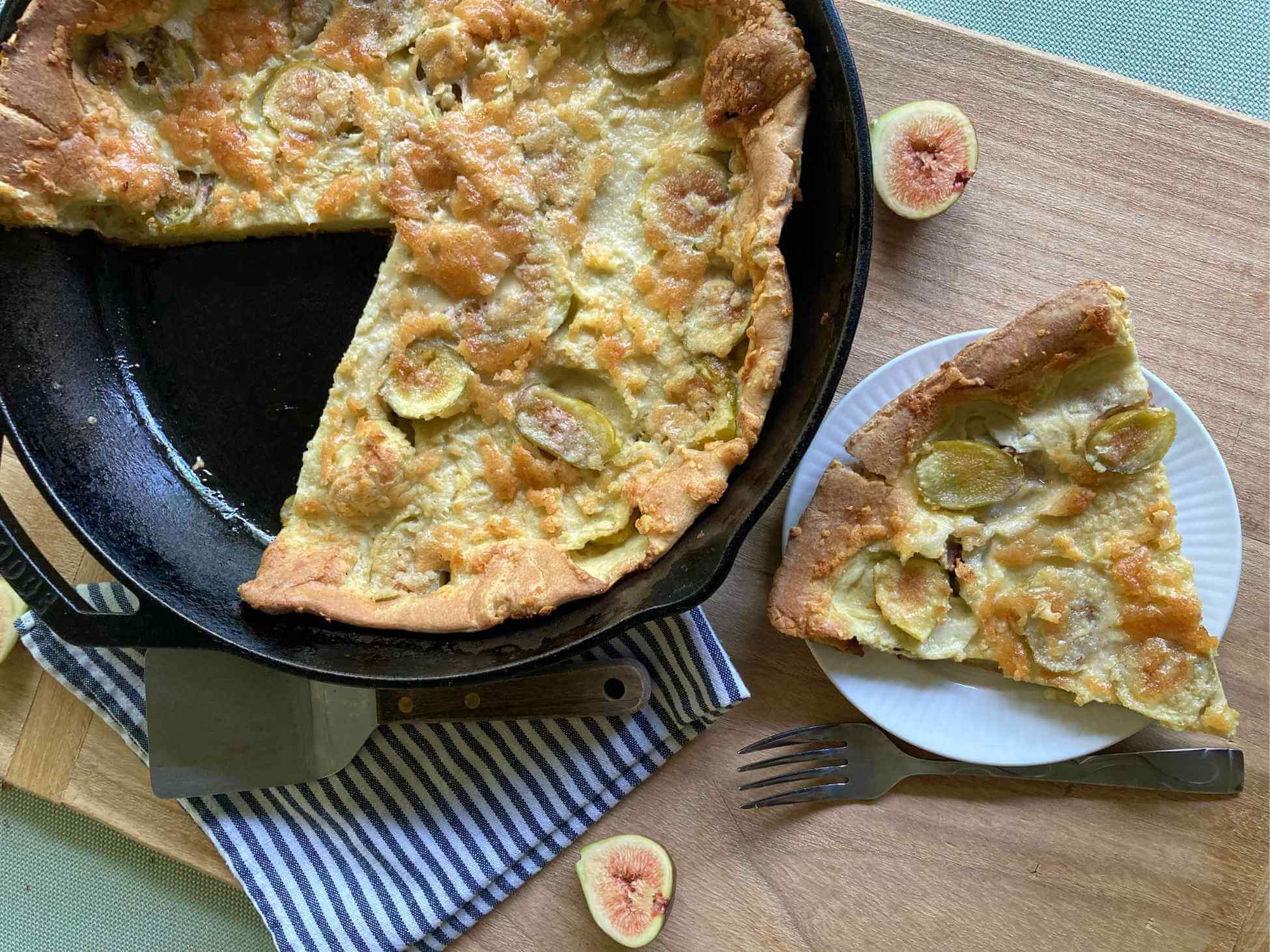 Fig Dutch baby in a skillet and a slice on a plate.