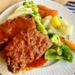 Gluten-free meatloaf on a plate with vegetables.