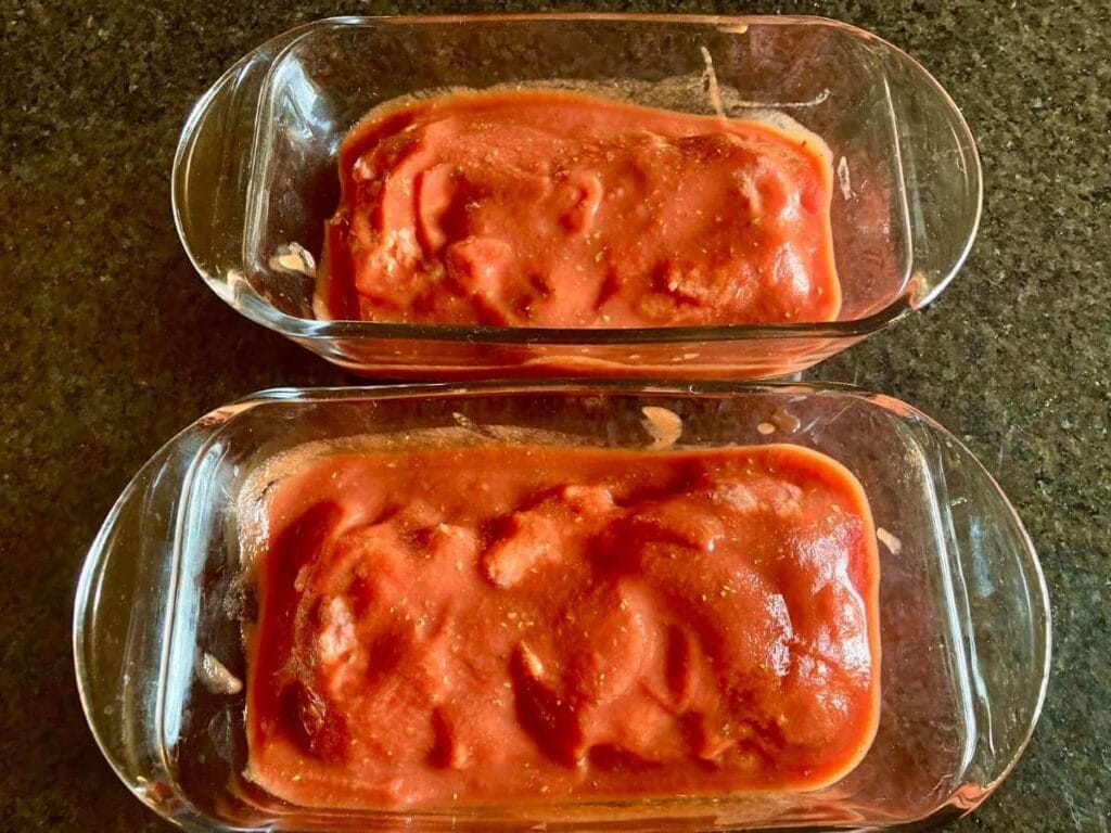 2 loaves of gluten-free meatloaf in pans before baking.