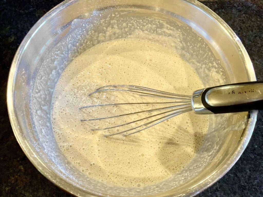 Whisking pancake batter in a bowl.