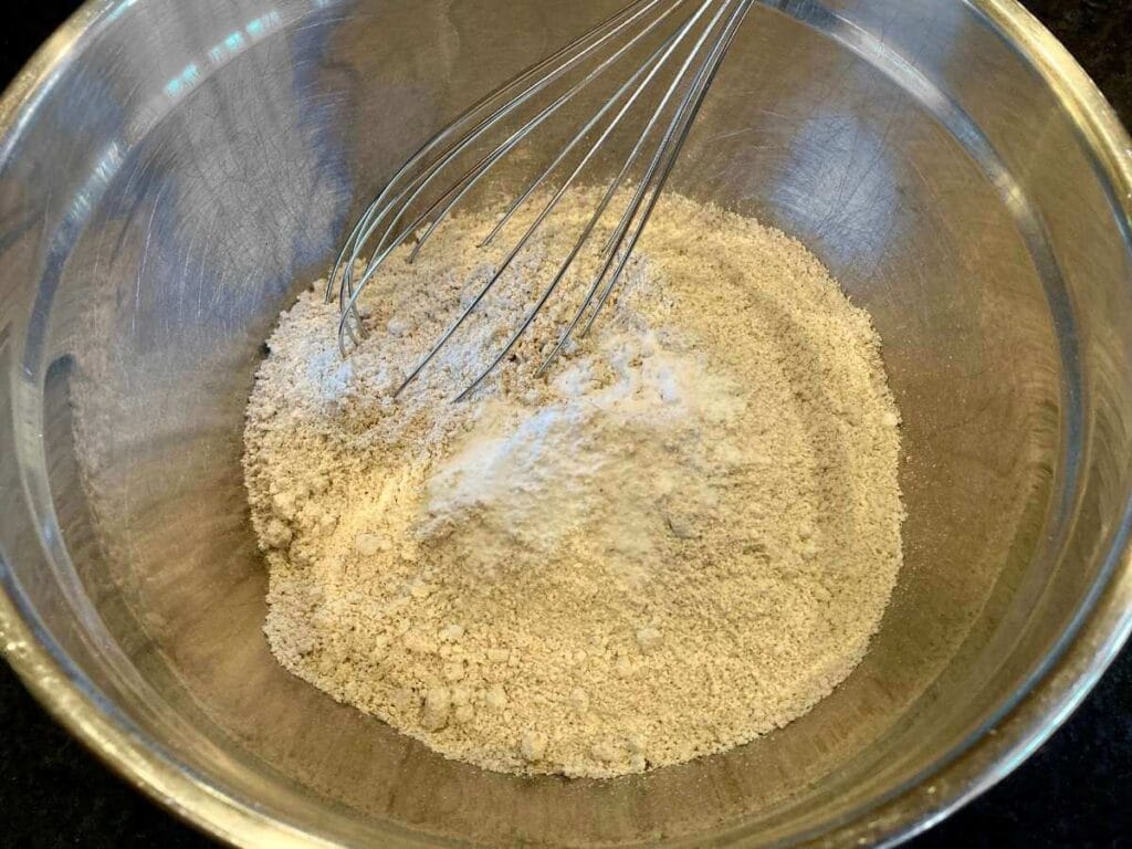 Whisking dry pancake ingredients together in a bowl.
