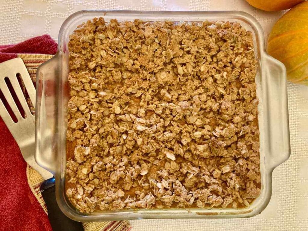 Gluten-free pumpkin cheesecake bars in a baking dish.