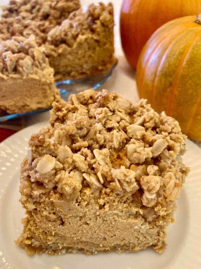 Closeup of a gluten-free pumpkin cheesecake bar on a plate.
